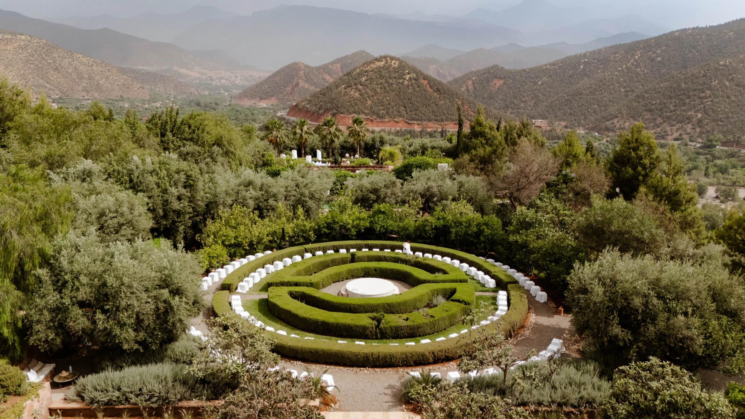 a maze in a garden with mountains in the background