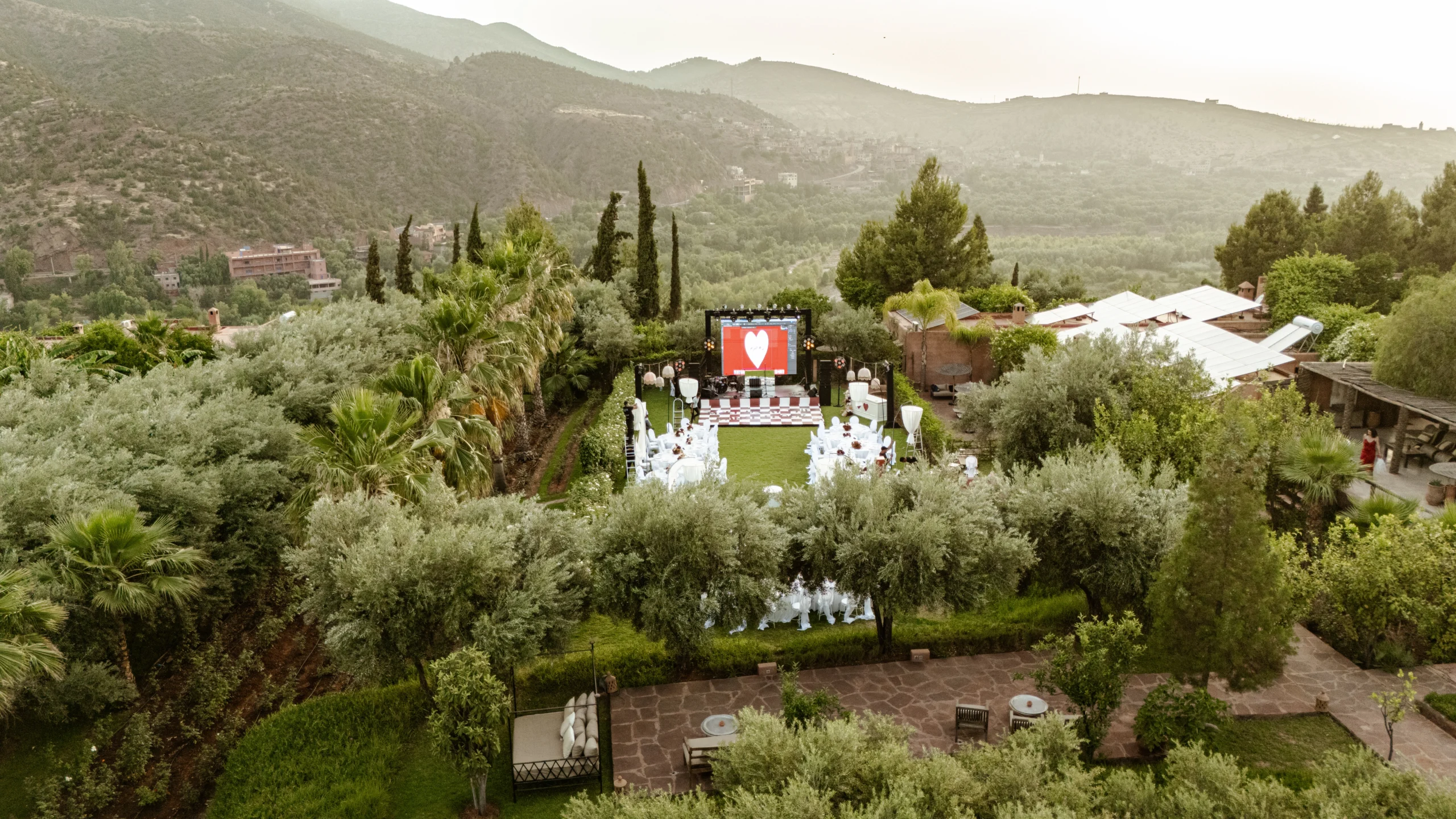 an outdoor event with trees and mountains in the background